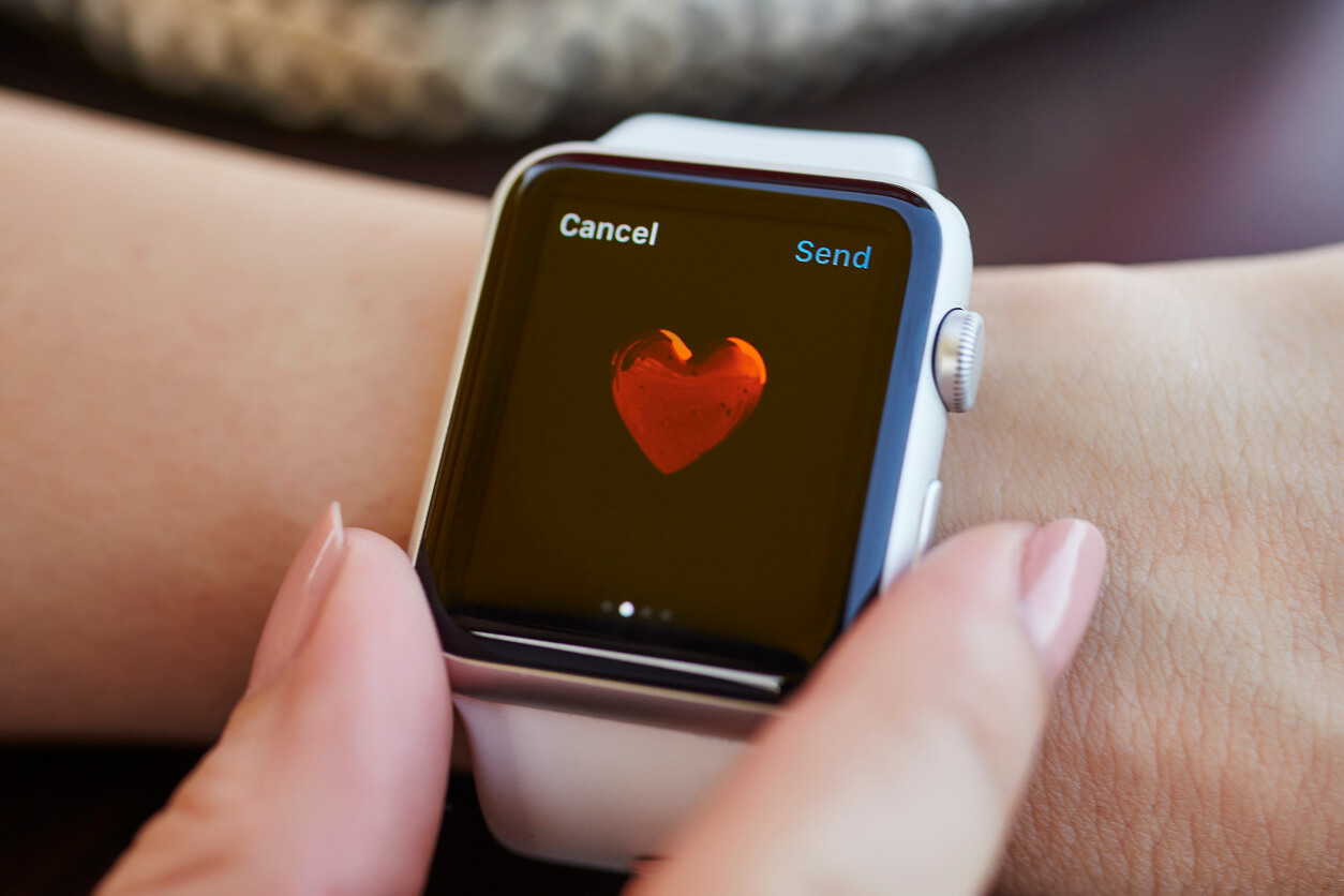 Apple Watch en mano presentando corazón de la aplicación de electrocardiogramas